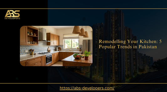 A professional banner titled "Remodelling Your Kitchen: 5 Popular Trends in Pakistan" by ABS Developers. It features a modern kitchen with wooden cabinets, a marble countertop, and traditional tiled backsplash.